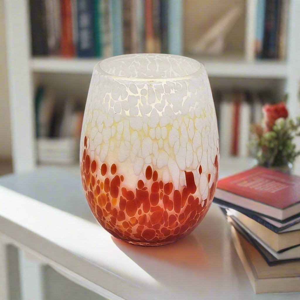 Red and white candle with bookcase in background